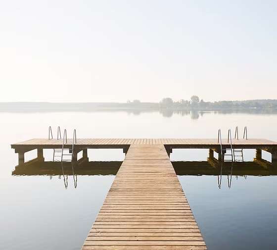 Ein Holzsteg führt auf einen ruhigen See hinaus